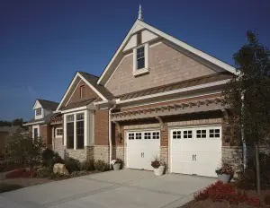 Brick home with double white garage doors